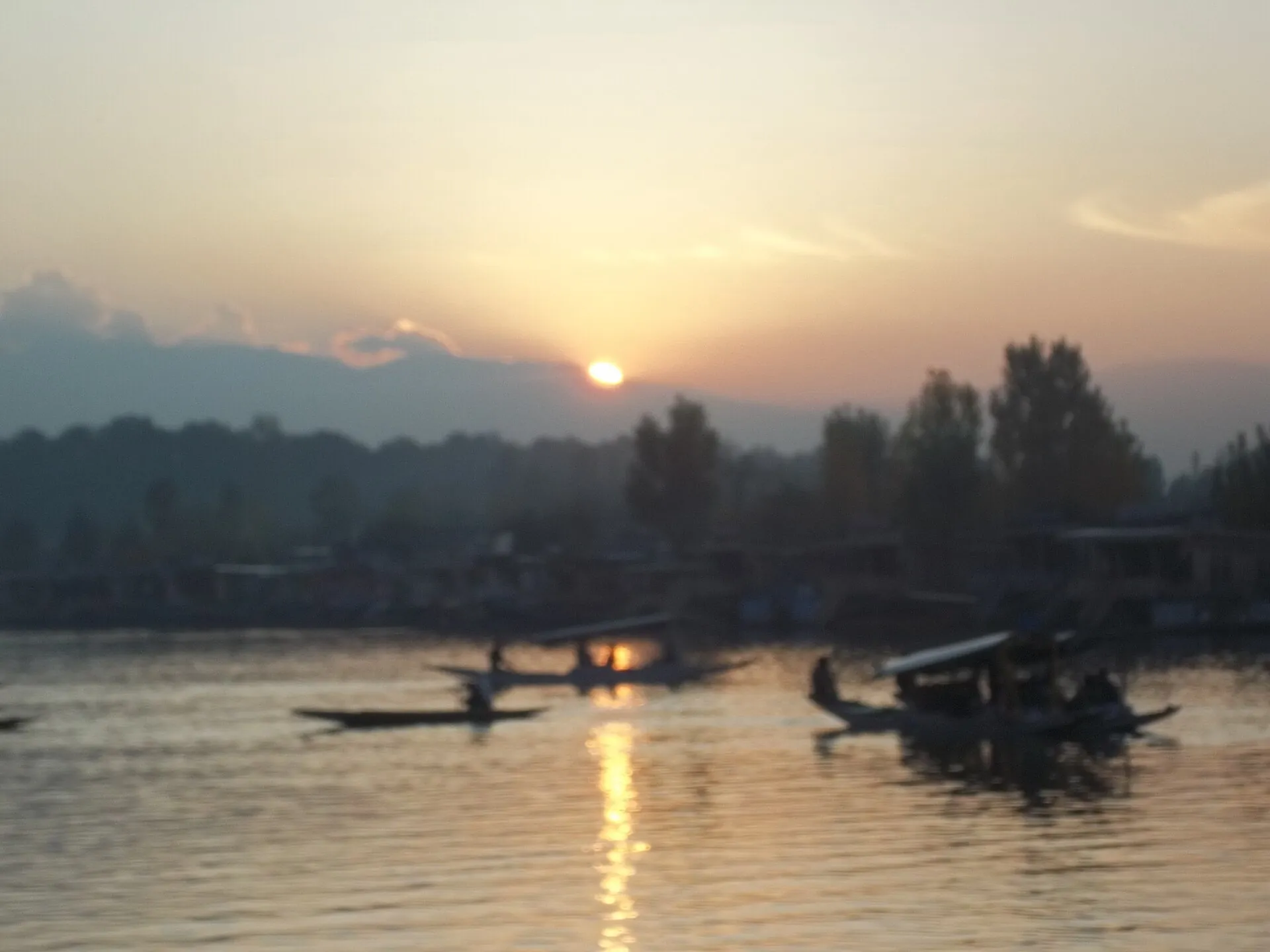 Silhouette of a shikara on Dal Lake at dusk